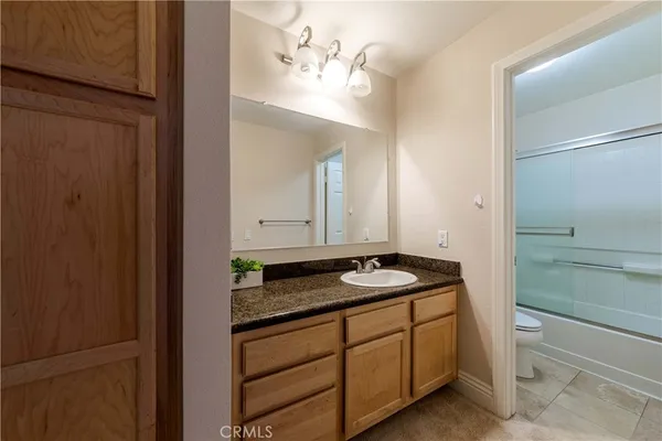 a bathroom with a granite countertop sink and a mirror