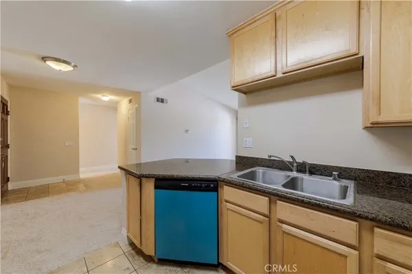 a kitchen with granite countertop stainless steel appliances a sink a stove and a refrigerator