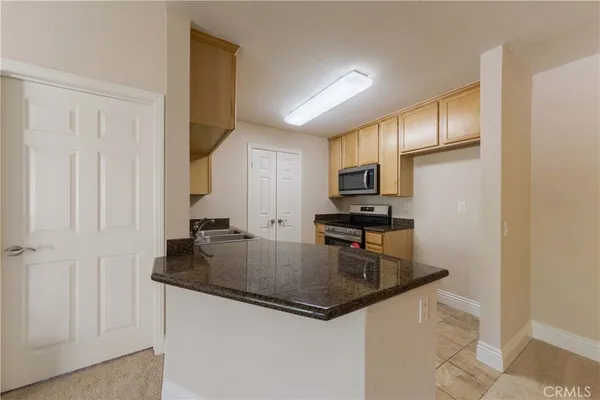 a kitchen with granite countertop a refrigerator a stove and a sink