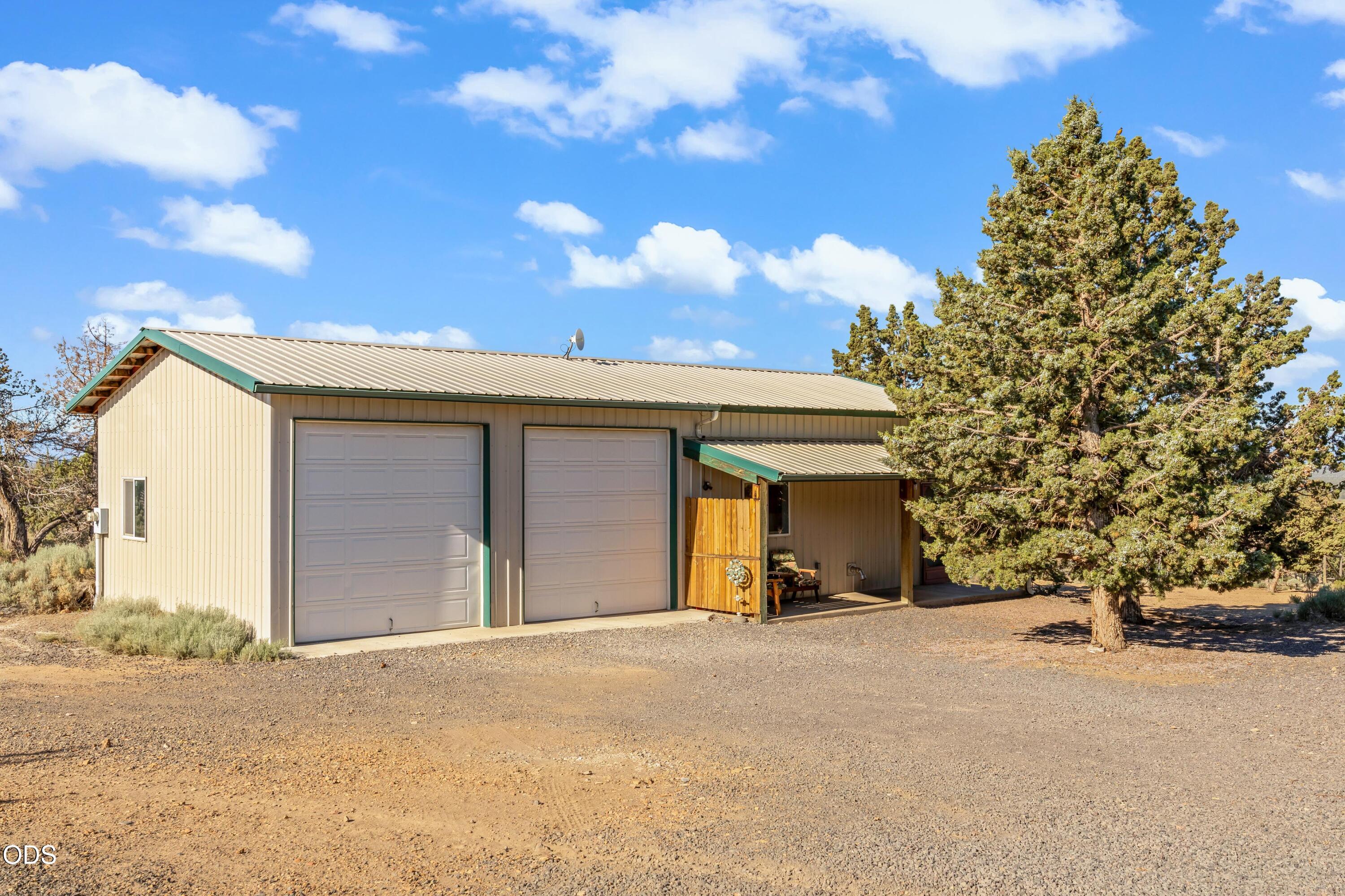 13753 South Sego Lily Road Powell Butte, OR 97753 - Photo 22 of 46 a view of a house with a yard and garage