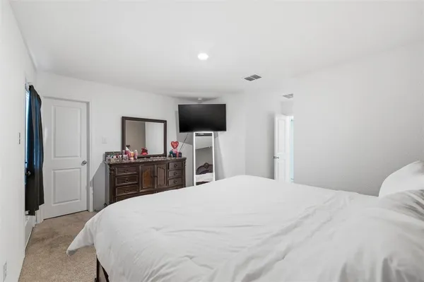 a bedroom with a bed and a television