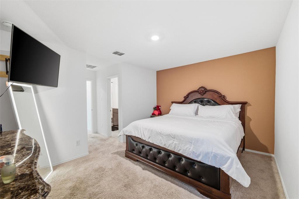 421 Corsair Way Ferris, TX 75125 - Photo 15 of 34 Bedroom with light colored carpet and ensuite bath