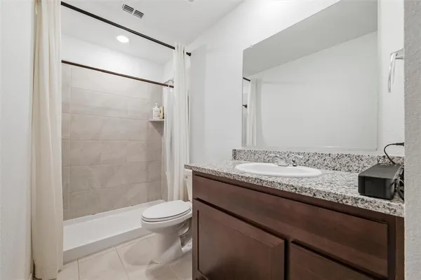 a bathroom with a granite countertop sink toilet a mirror and shower