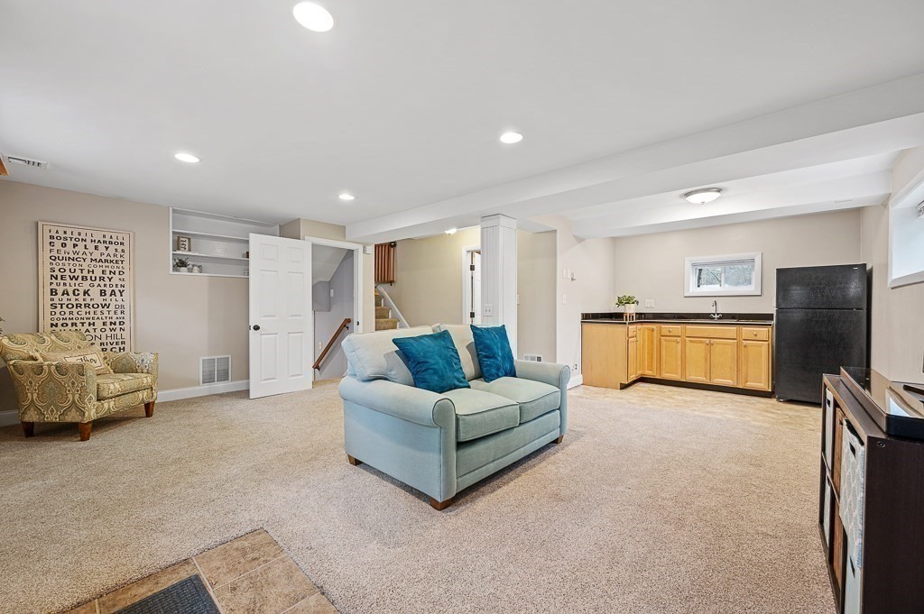 12 Sycamore Road Sudbury, MA 01776 - Photo 22 of 38 a living room with furniture and a flat screen tv