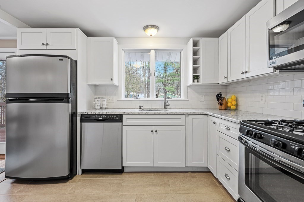 12 Sycamore Road Sudbury, MA 01776 - Photo 9 of 38 a kitchen with white cabinets and white appliances