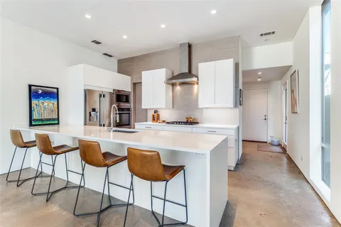 a kitchen with stainless steel appliances kitchen island granite countertop a refrigerator and a stove top oven