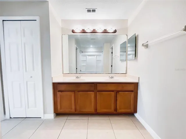 a bathroom with a double vanity sink and a mirror