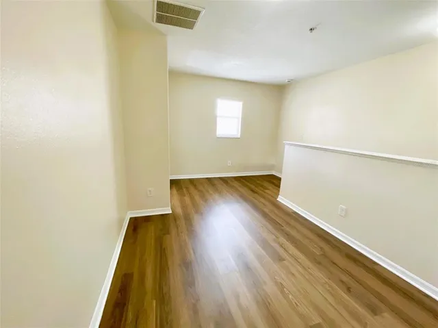 a view of a room with wooden floor and a window