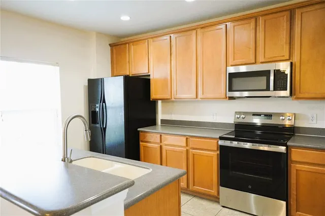 a kitchen with a stove a sink and a microwave