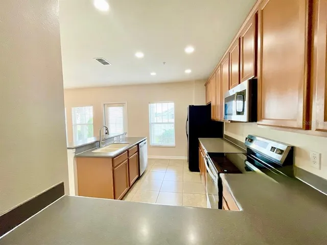 a kitchen with granite countertop a stove and a refrigerator