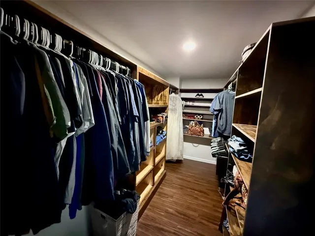 a view of walk in closet with clothes and shoes