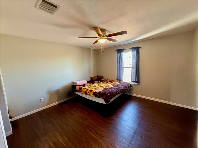 a bedroom with bed and wooden floor