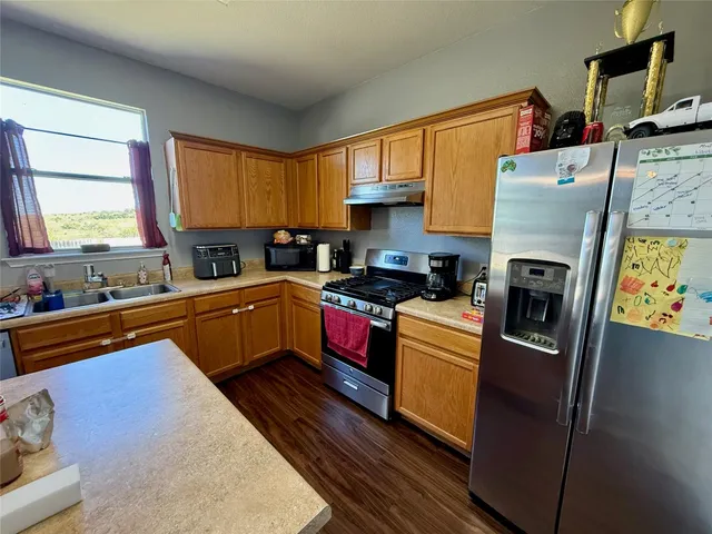 a kitchen with stainless steel appliances a refrigerator sink and cabinets