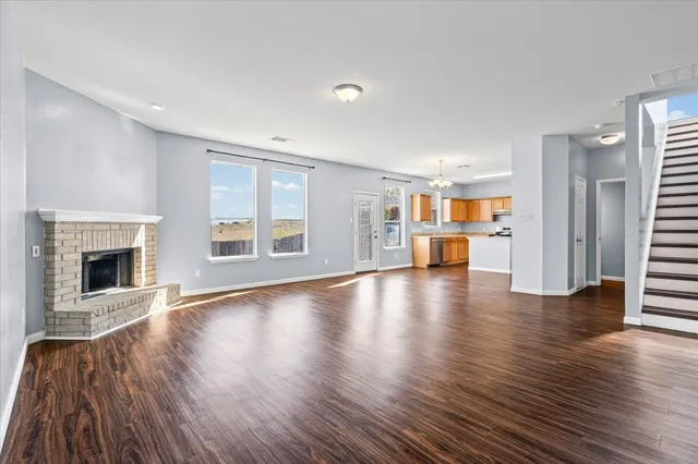 a view of a livingroom with wooden floor and a fireplace