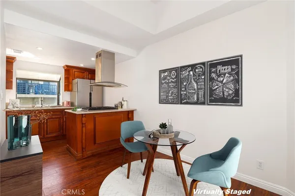 a kitchen with stainless steel appliances kitchen island granite countertop a dining table and chairs
