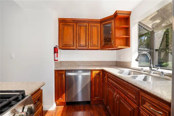 a kitchen with stainless steel appliances granite countertop a sink stove and cabinets