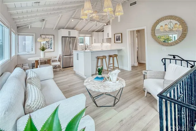 a living room with furniture a chandelier and wooden floor