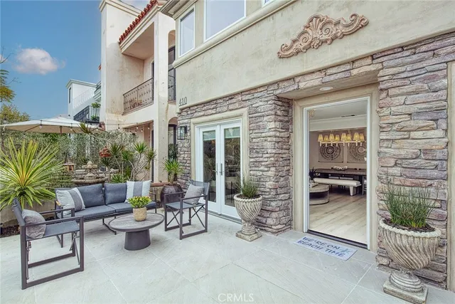a view of a patio with dining table and chairs and potted plants