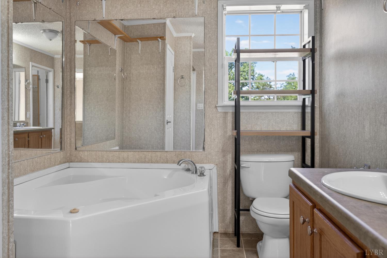 1811 Mohawk Road Gladys, VA 24554 - Photo 11 of 51 a bathroom with a granite countertop toilet a sink and a bathtub