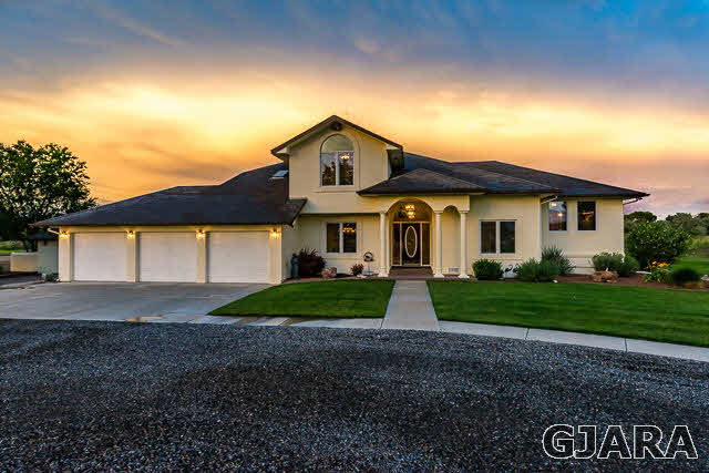 810 25 Road Grand Junction, CO 81505 - Photo 1 of 9 a front view of a house with a yard and garage