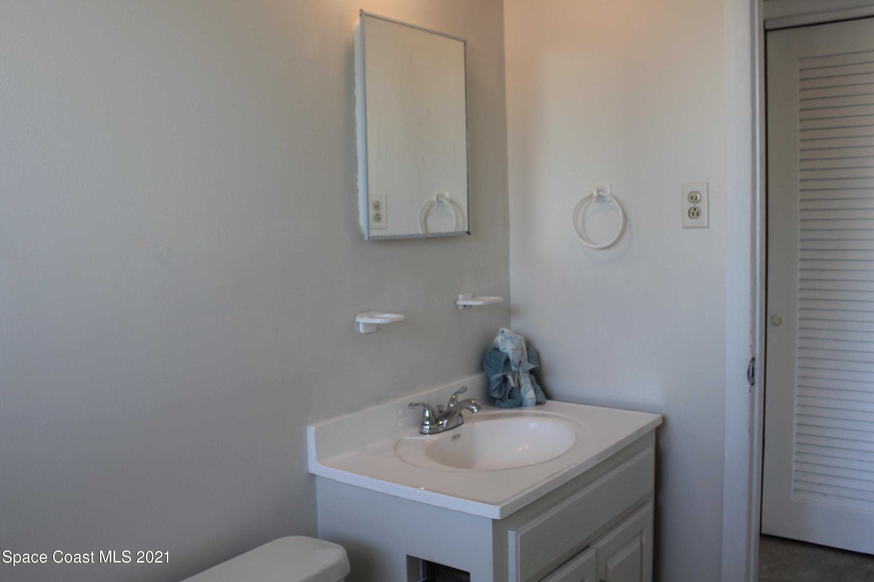 651 Palm Drive, Unit E1 Satellite Beach, FL 32937 - Photo 16 of 18 a bathroom with a sink and a toilet