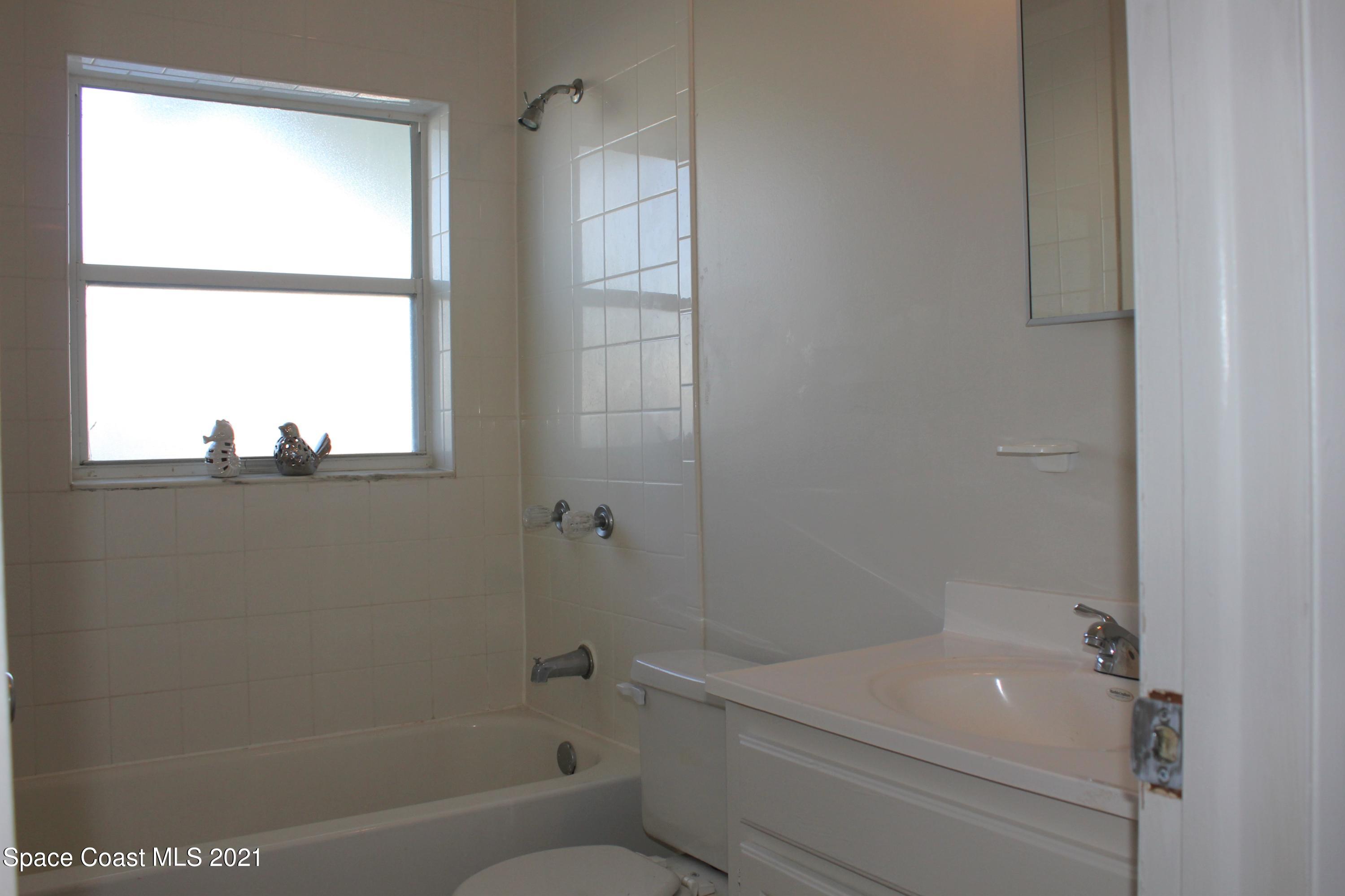 651 Palm Drive, Unit E1 Satellite Beach, FL 32937 - Photo 17 of 18 a bathroom with a sink a toilet and shower