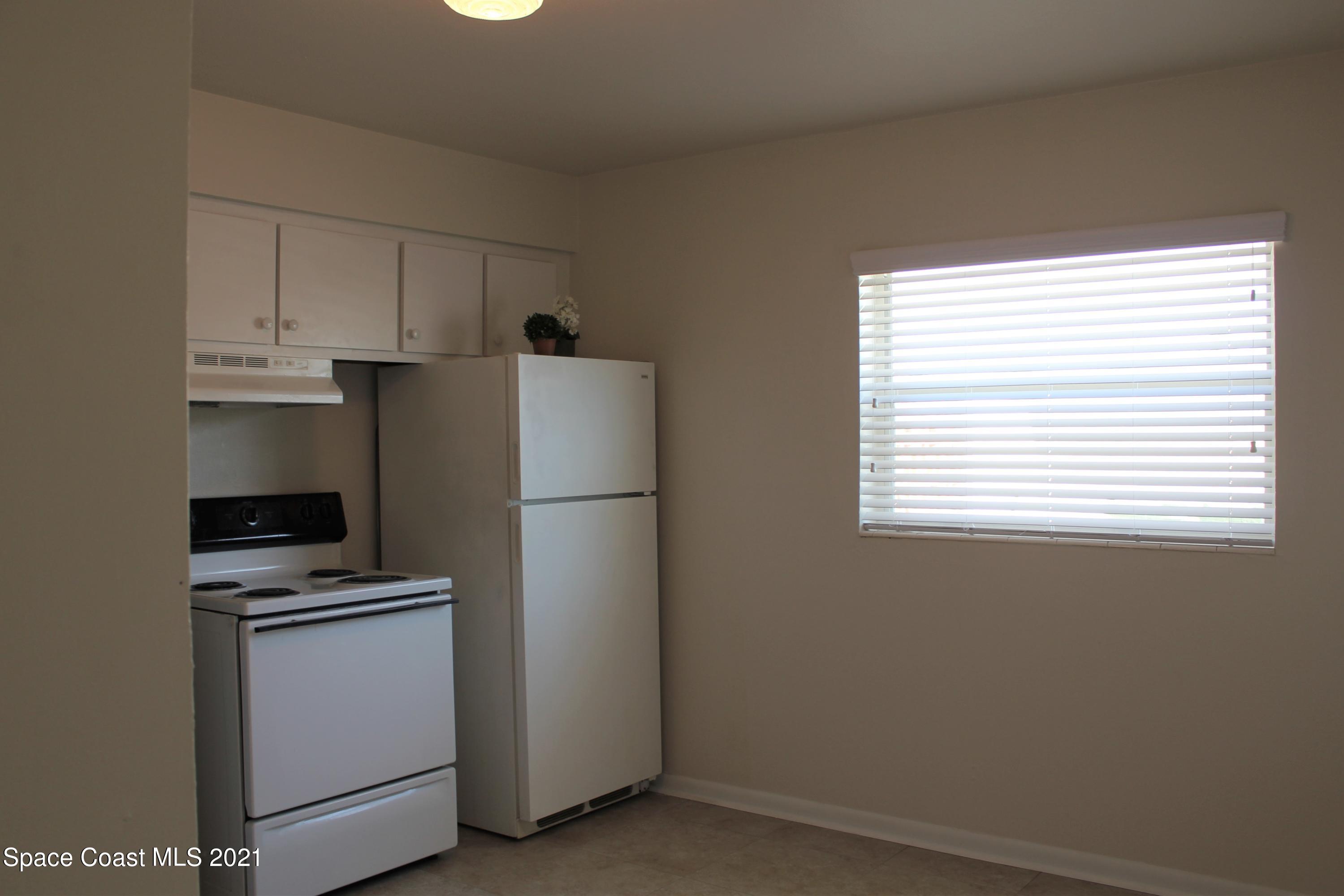 651 Palm Drive, Unit E1 Satellite Beach, FL 32937 - Photo 10 of 18 a kitchen with cabinets a refrigerator and a stove