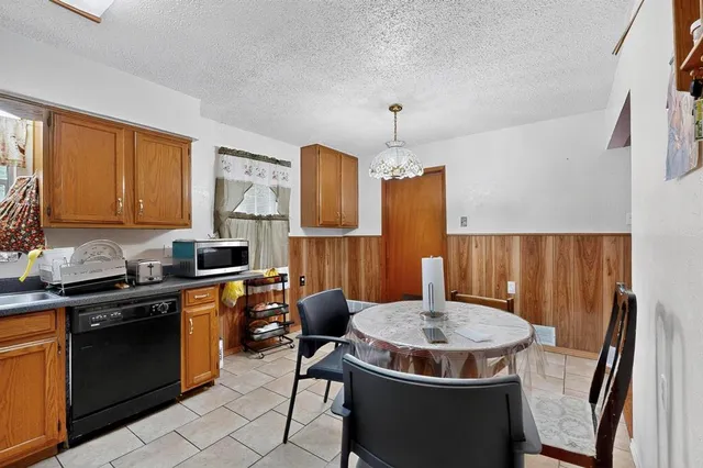a kitchen with a table chairs sink and wooden floor