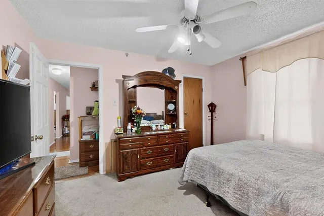 a bedroom with a bed and a flat tv screen on dresser