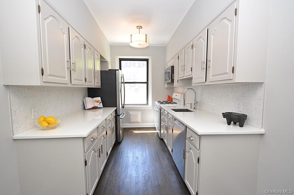 143 Garth Road, Unit 4P Scarsdale, NY 10583 - Photo 12 of 44 Updated Eat-In-Kitchen has Quartz counters and stainless steel appliances.