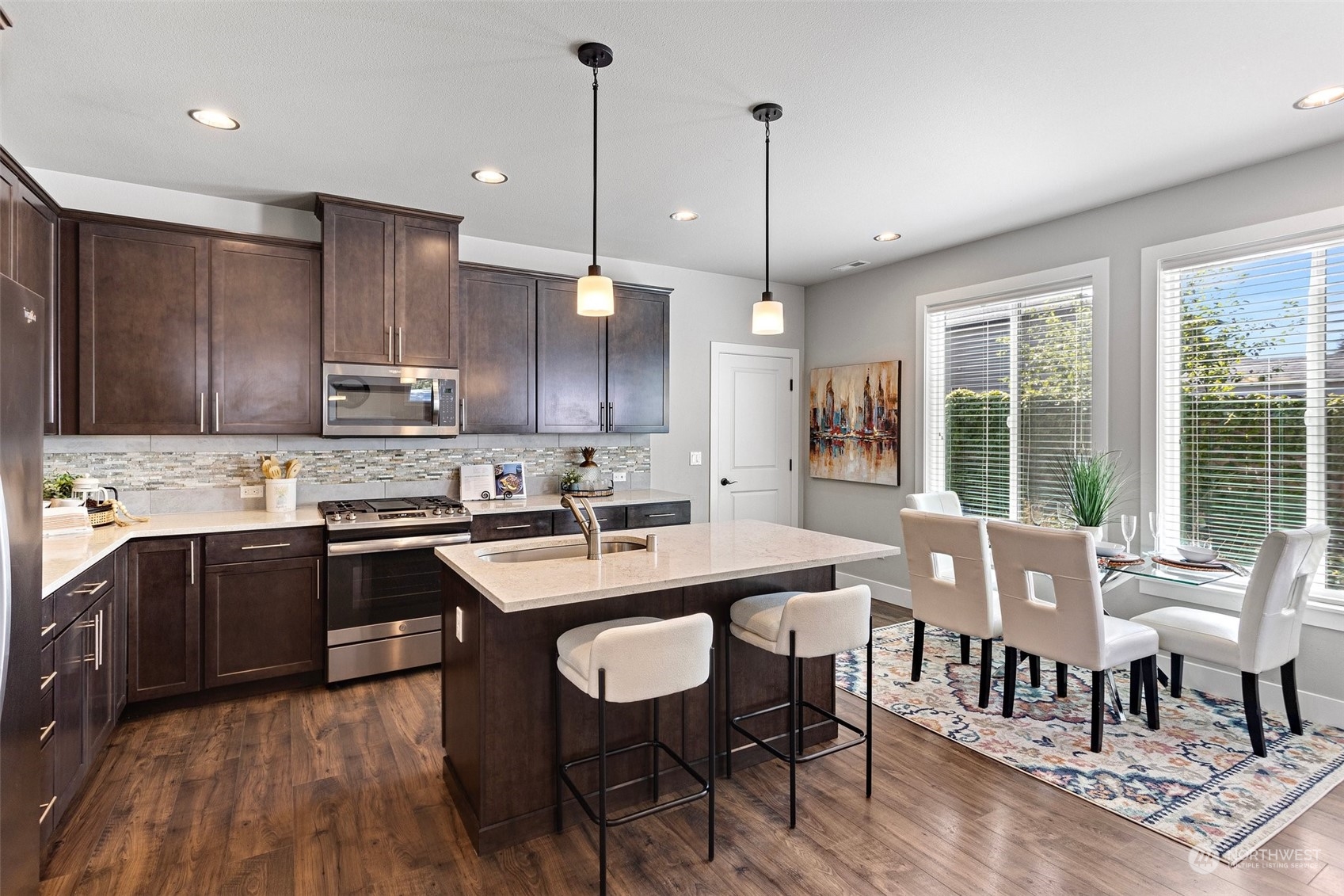 11317 Southeast 162nd Street Renton, WA 98055 - Photo 10 of 33 a kitchen with stainless steel appliances granite countertop a stove top oven a sink a dining table and chairs