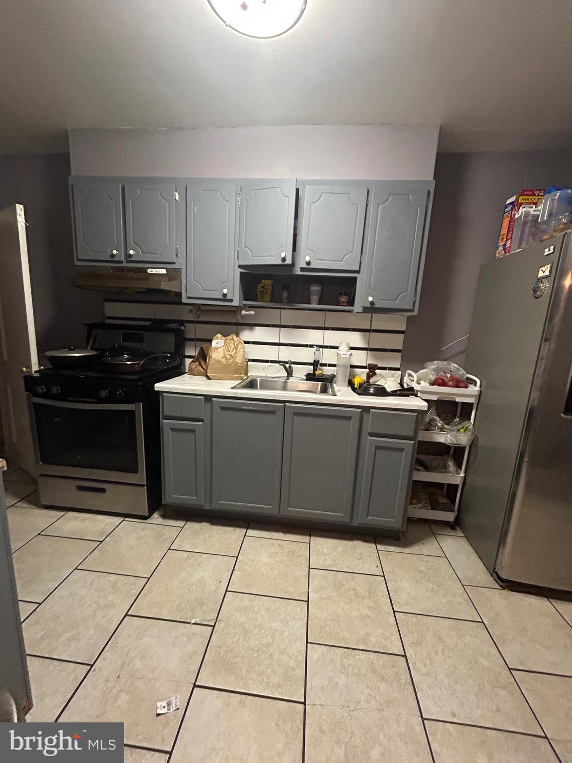 5331 Tabor Avenue Philadelphia, PA 19120 - Photo 14 of 18 a kitchen with a stove a sink and a microwave