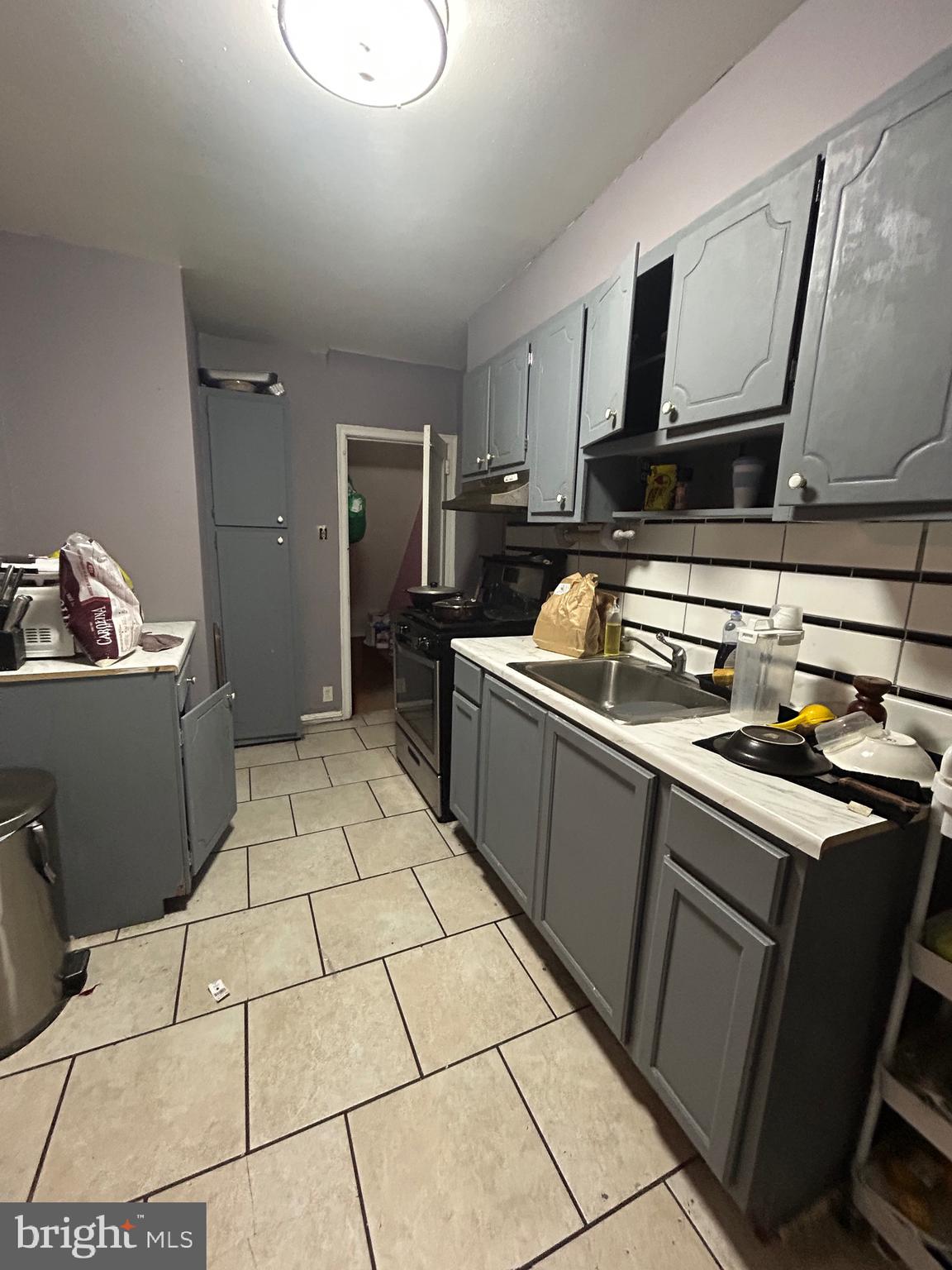 5331 Tabor Avenue Philadelphia, PA 19120 - Photo 16 of 18 a kitchen with a sink a stove and cabinets
