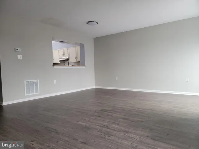 a view of a kitchen with wooden floor and a window