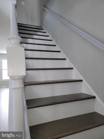 a view of staircase with white walls and empty racks