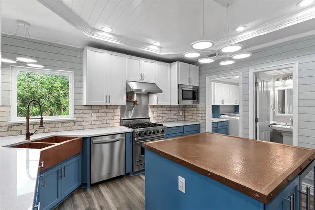 a kitchen with stainless steel appliances granite countertop a sink a stove and a refrigerator