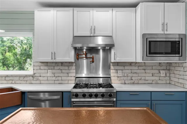 a stove top oven sitting inside of a kitchen