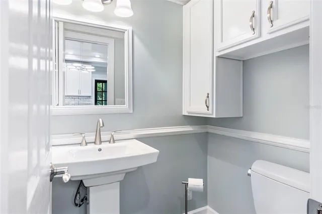 a bathroom with a sink a toilet and mirror