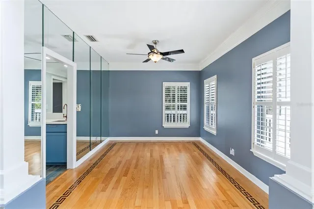 a view of an empty room with a window and wooden floor
