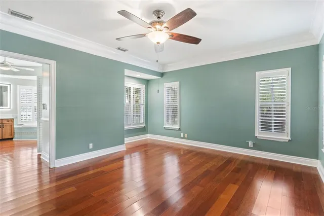 a view of an empty room with window and wooden floor