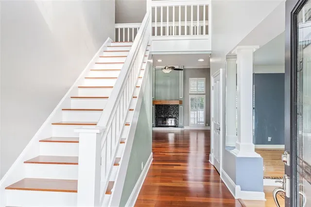 a view of a hallway with wooden floor and staircase