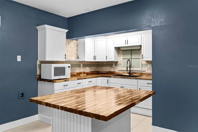 a kitchen with stainless steel appliances granite countertop a table chairs sink and cabinets