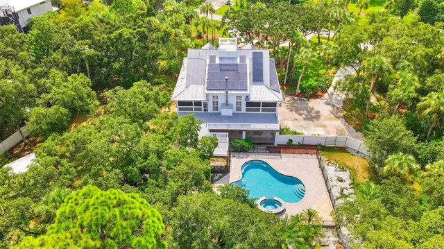 an aerial view of a house with swimming pool and garden view