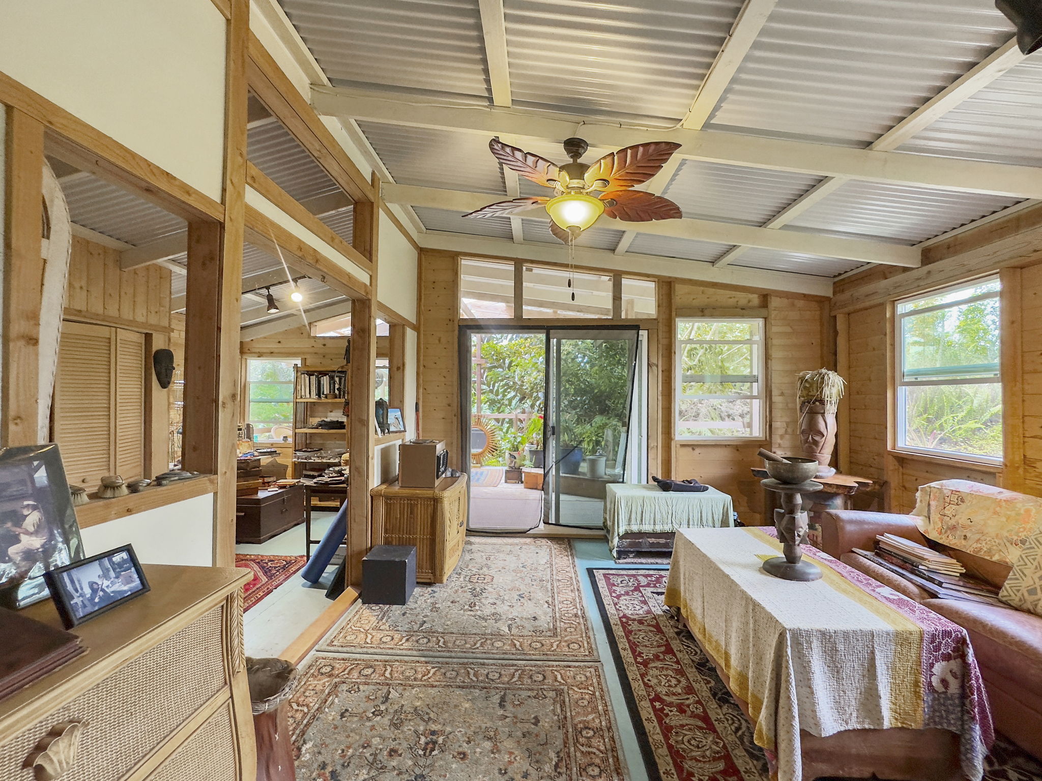 92-1347 Rd To The Sea Ocean View, HI 96704 - Photo 17 of 30 a living room with furniture a flat screen tv and a table