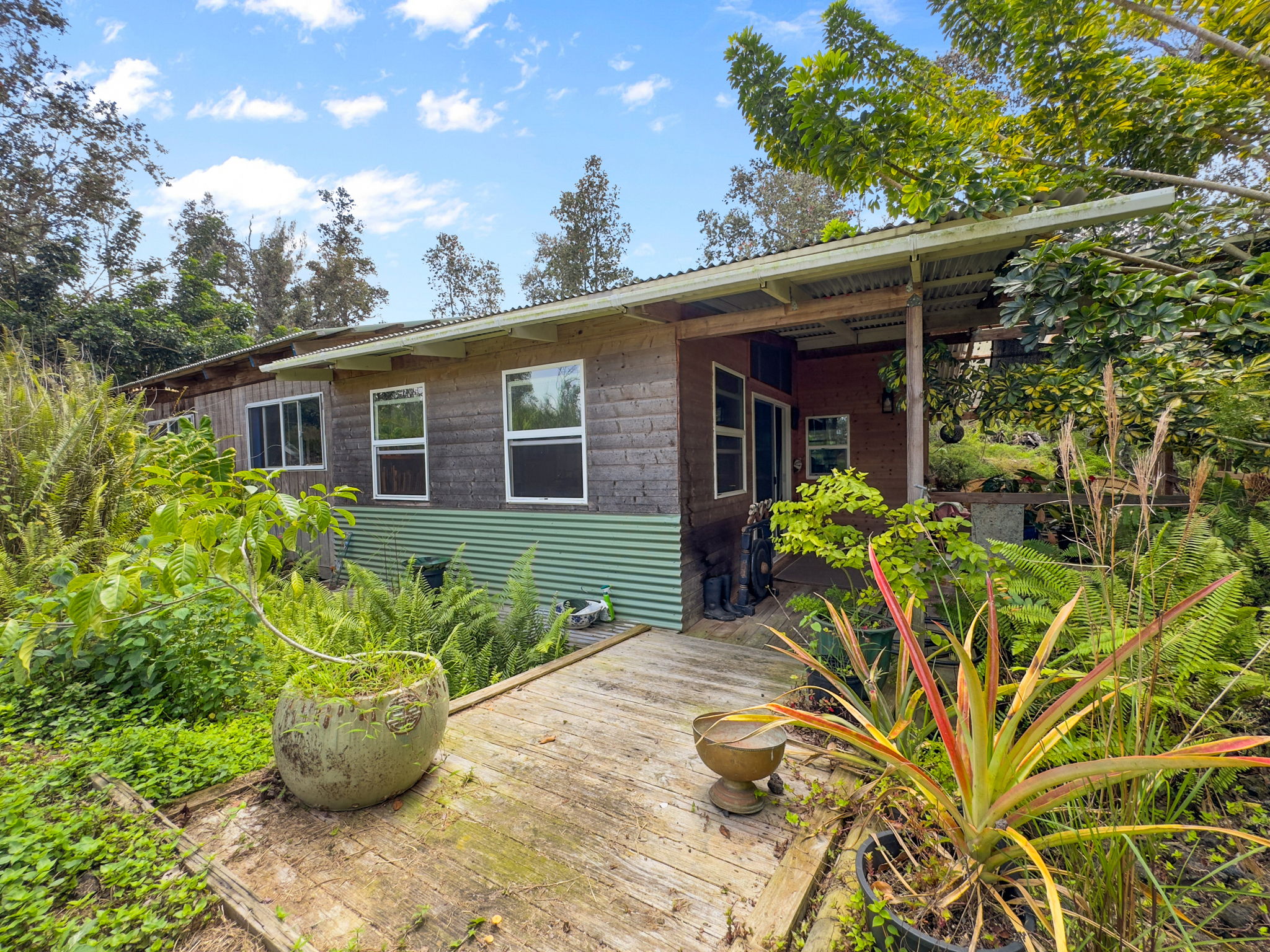 92-1347 Rd To The Sea Ocean View, HI 96704 - Photo 20 of 30 a front view of a house with a garden