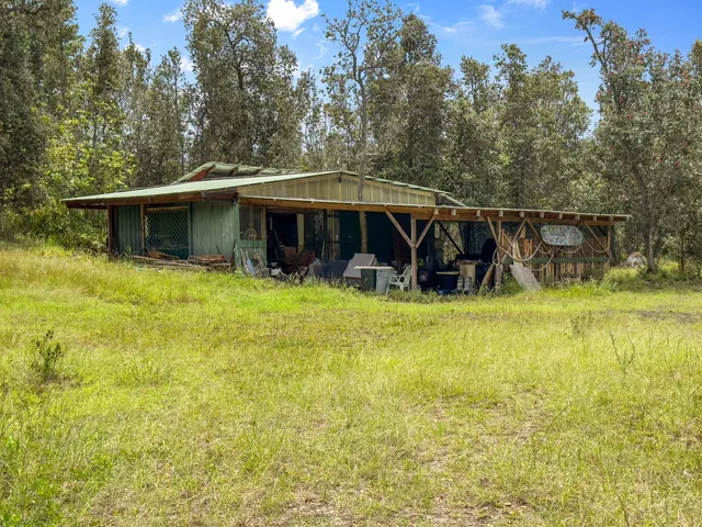 a view of a house with floor to ceiling windows and a yard