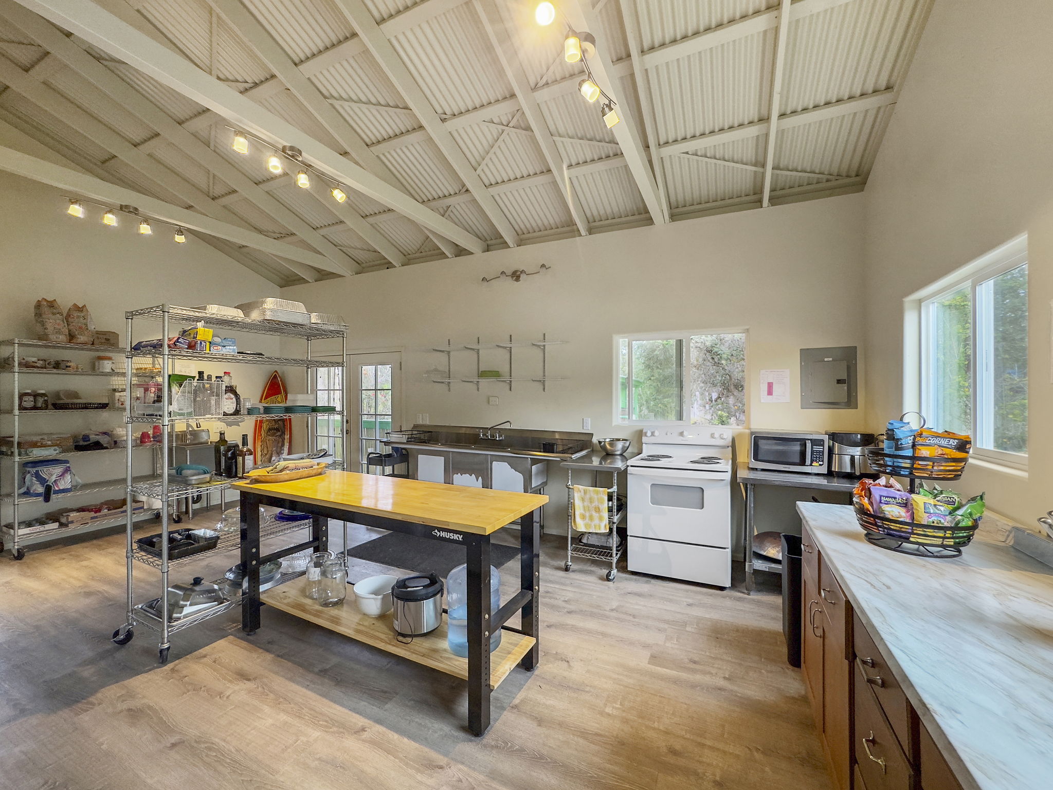 92-1347 Rd To The Sea Ocean View, HI 96704 - Photo 7 of 30 a kitchen with lots of counter top space and a wooden floor