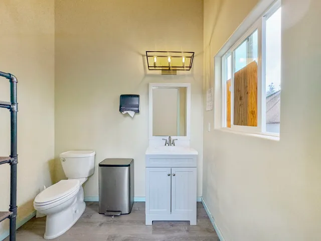 a bathroom with a toilet a sink and mirror