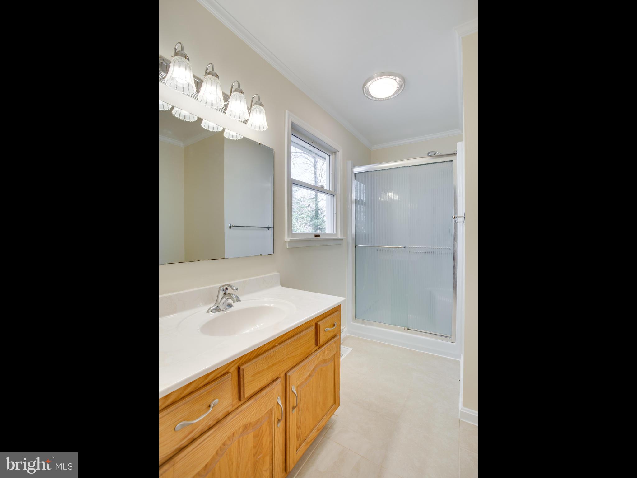 491 Round Up Road Lusby, MD 20657 - Photo 22 of 30 a bathroom with a sink a shower and a mirror