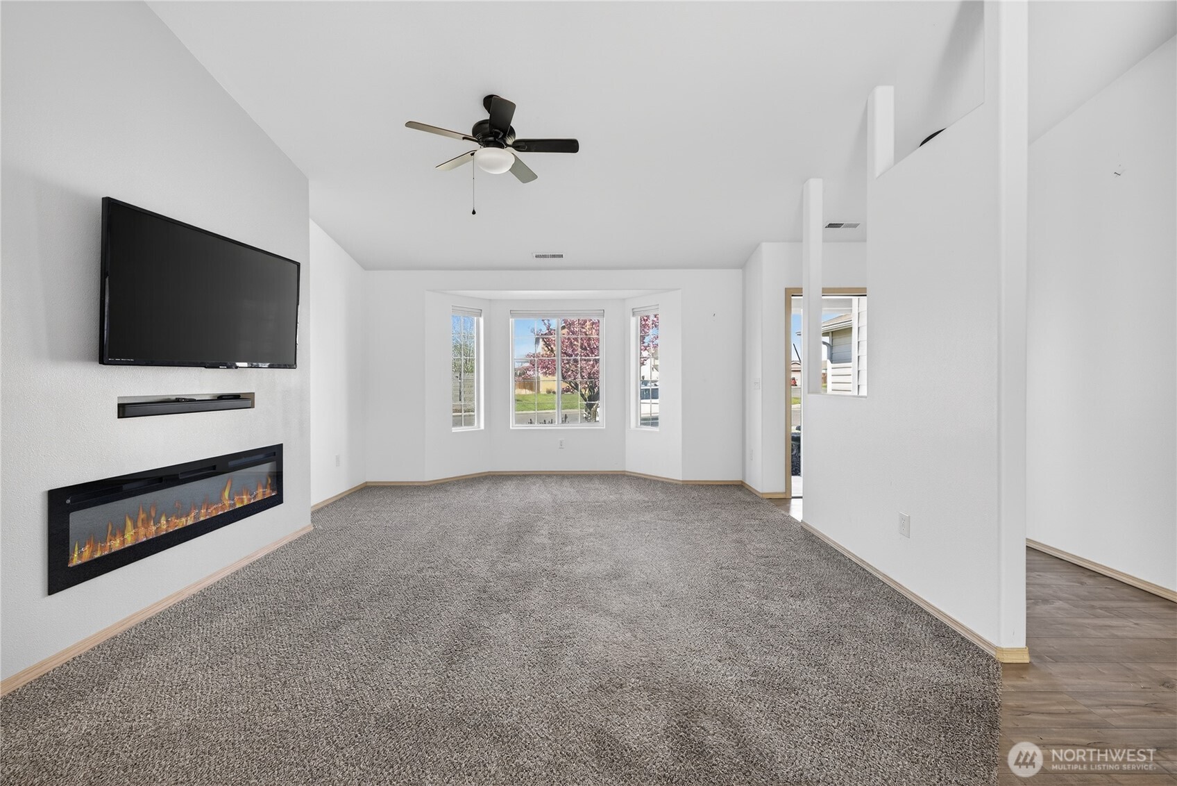 4607 Santa Fe Lane Pasco, WA 99301 - Photo 2 of 28 an empty room with windows and ceiling fan